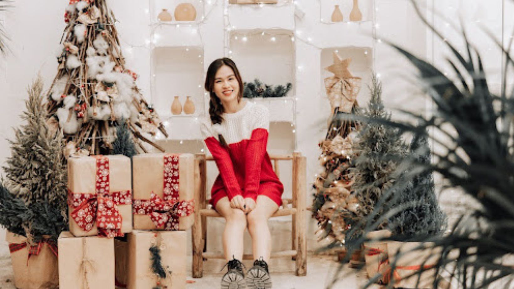 woman in holiday clothes surrounded by Christmas decorations